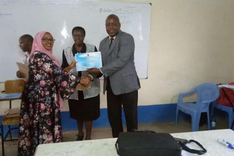 A student being awarded a certificate after successful completion of  SPSS training.