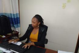 Ms. Mercy Isigi Anjeo at her desk doing her attachement duties at ODeL Campus